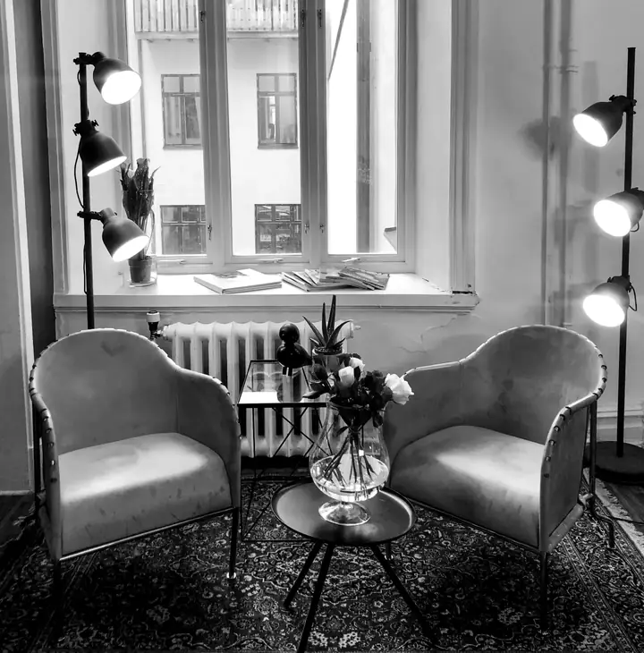 Salongens loungehörna med fåtöljer vid det stora fönstret på Drottninggatan 7